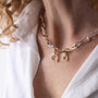 Gold and silver infinity chain necklace with stirrup clasp person in a white shirt.
